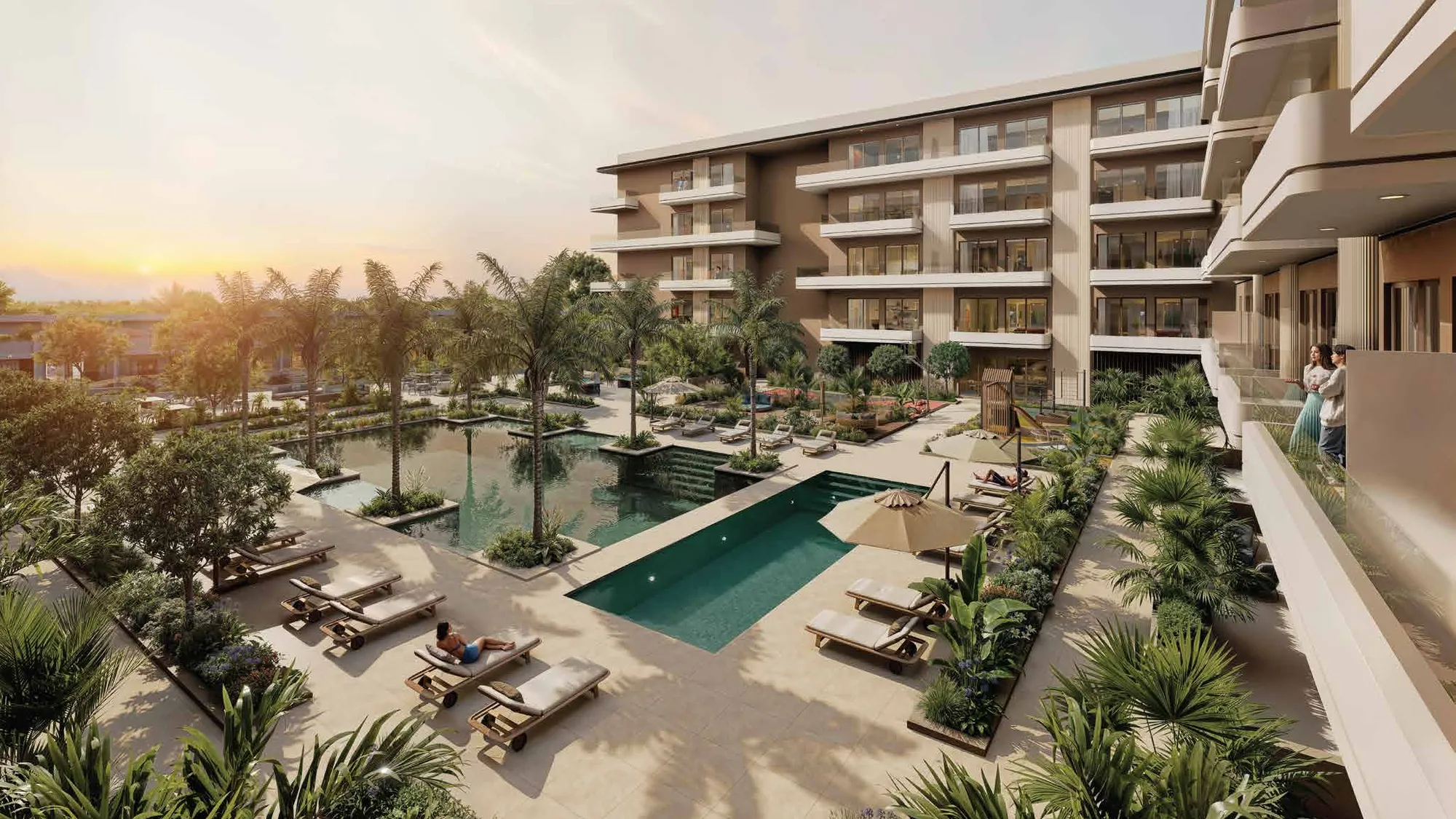 Palm-lined courtyard pools and loungers at sunset beside the residences